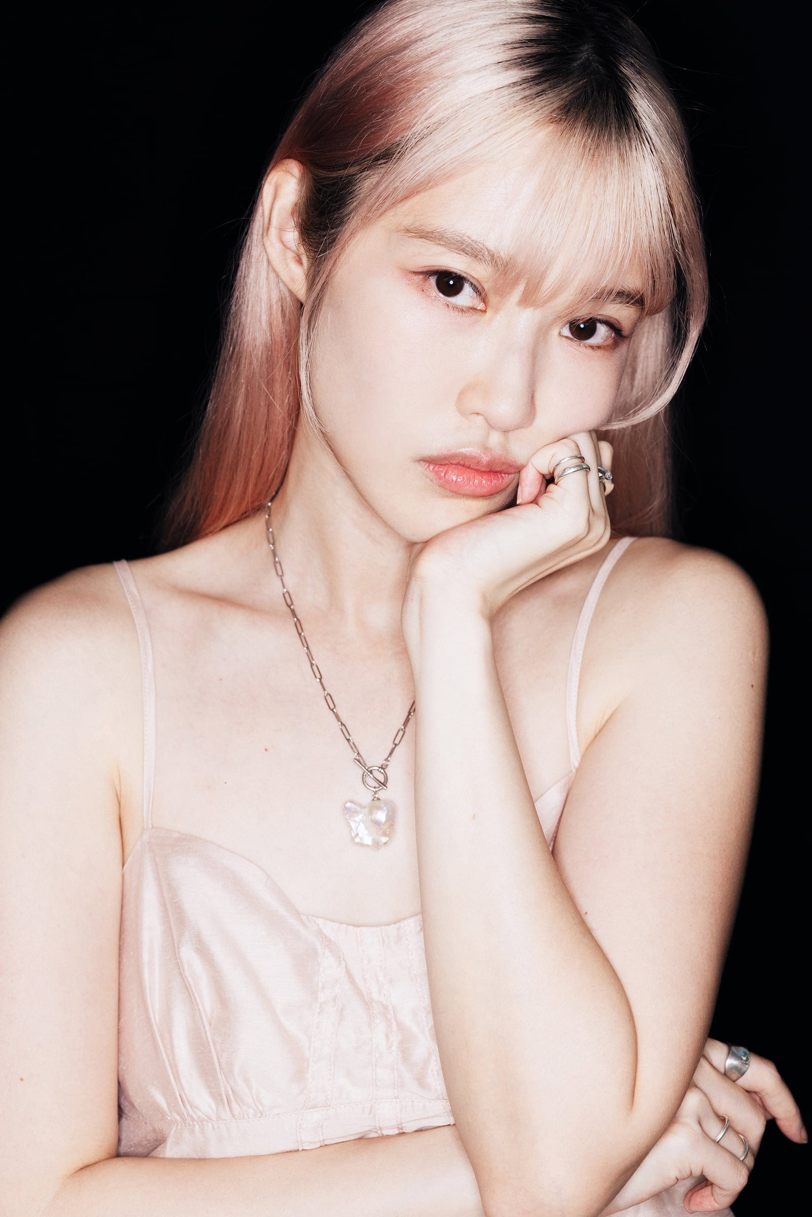 Bell in a pale dress against a black background